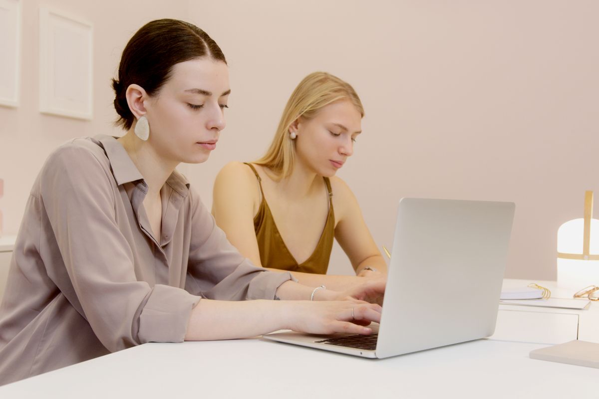 Two colleagues going through work on a laptop